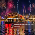 Guests enjoying a festive New Year’s Eve dinner cruise with Dubai’s illuminated skyline in the background.